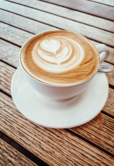 Latte Art in einer Tasse auf einem Holztisch