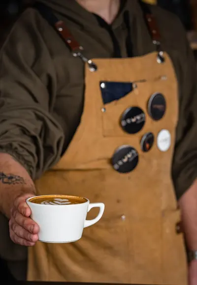 Barista serviert einen Latte in einem Café