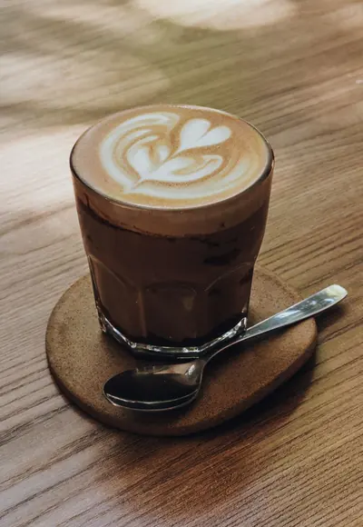Flat White mit Latte Art auf einem Holztisch