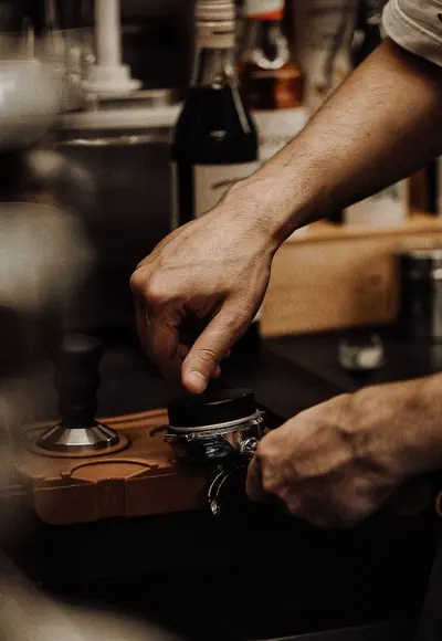 Barista bereitet einen Espresso mit dem Siebträger zu
