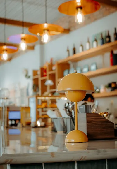 Café-Interieur mit Pendelleuchten und gelber Tischlampe